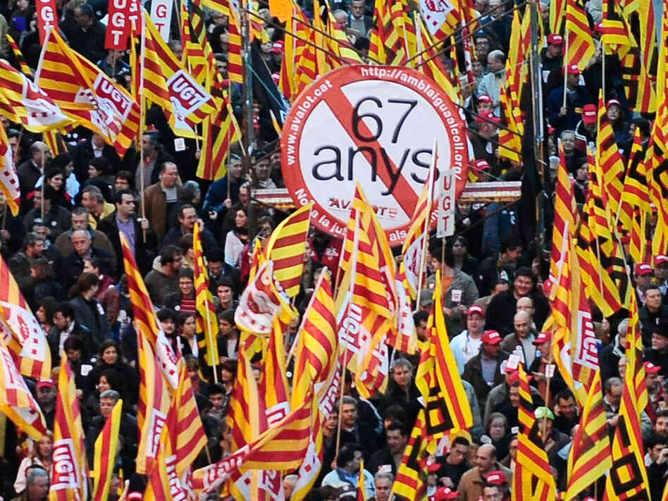 People protest against government plans to raise the retirement age in Barcelona, Spain.