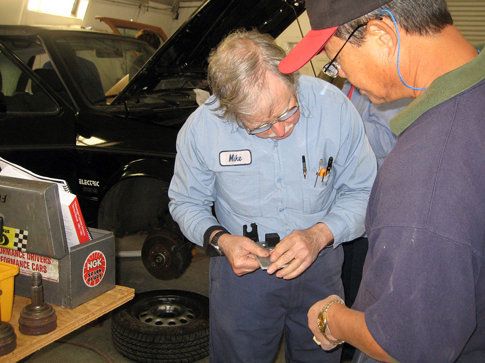 Mike Brown (left), owner of Electro Automotive, works on a gas-to-electric car conversion with a student, Daniel Marcom. Brown has been selling the parts to make such conversions since 1979.