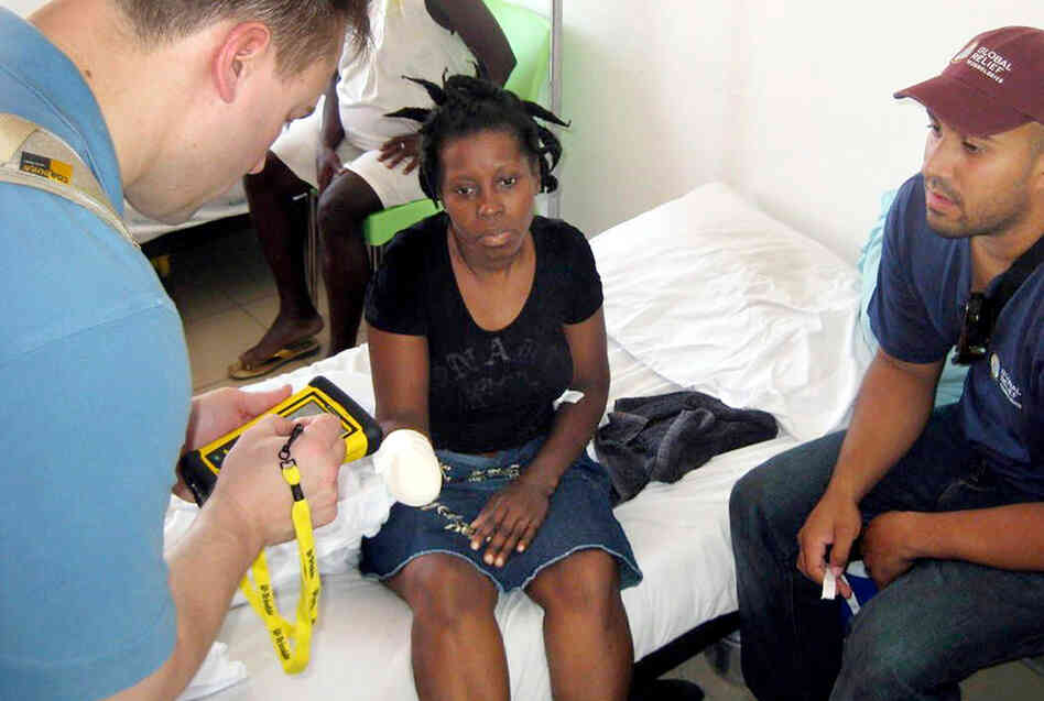 With the help of a translator, an aid worker in Haiti enters the medical data of a woman. With the help of a translator, an aid worker in Haiti enters the medical data of a woman.