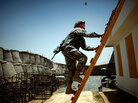 Lt. Col. Johnny Davis climbs on to the roof of a building Lt. Col. Johnny Davis climbs on to the roof of a building