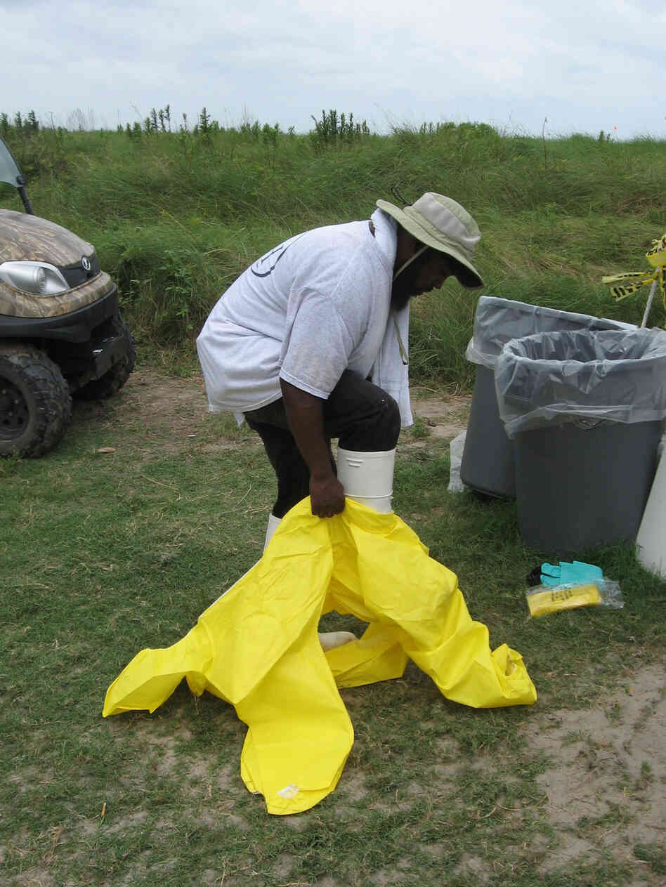 Jerome Benjamin of New Orleans slips into a yellow hazardous material suit.