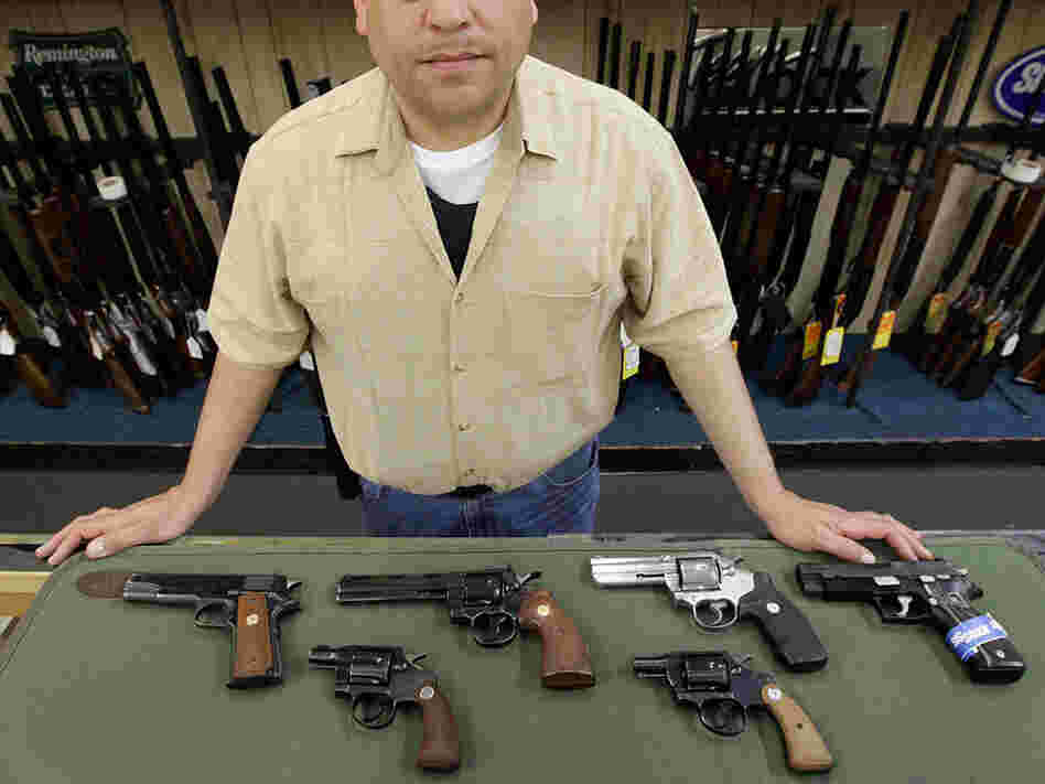 Mark Diaz, manager of Schrank's Smoke 'n Gun shop, displayed several handguns for sale at the store.