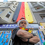 Ibrahim Bassal, Beirut-born shopkeeper, stands near the German flag displayed over his shop