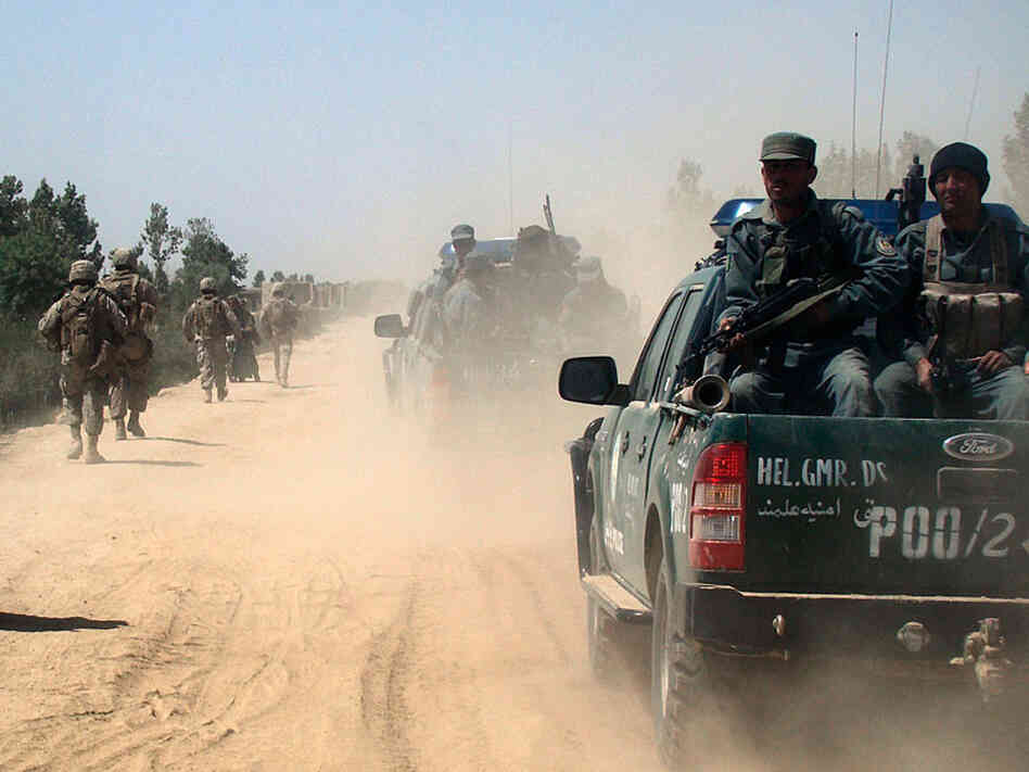 Afghan police and U.S. Marines patrol the city of Marjah