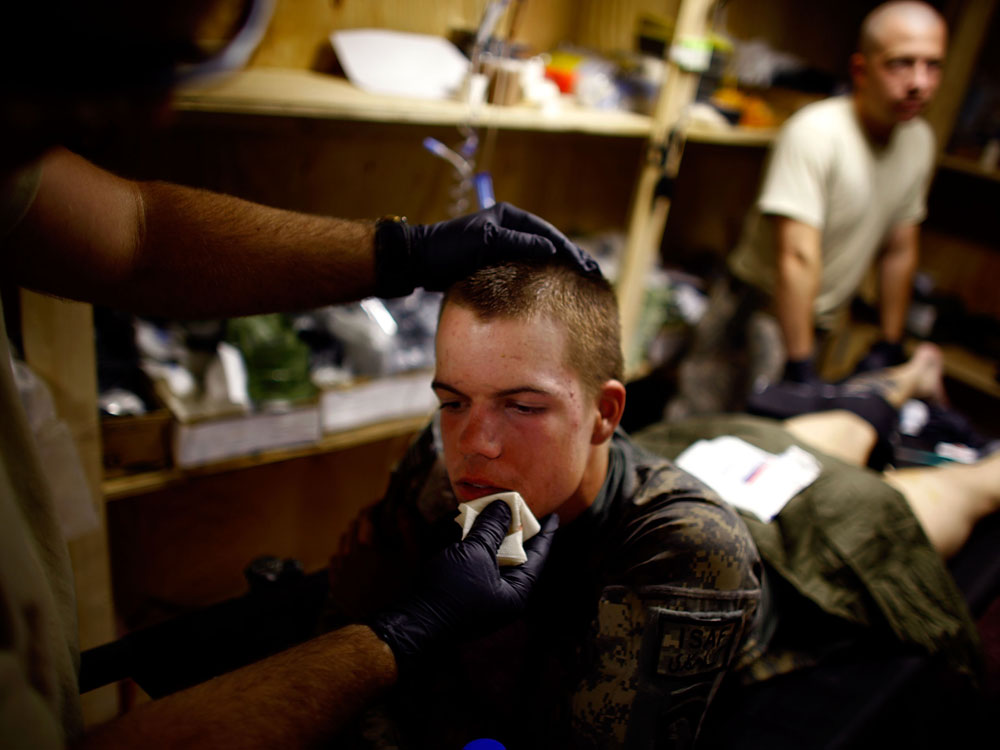 Pvt. Dan Oswald with Alpha Company is cared for by medics after being hit by shrapnel from a grenade