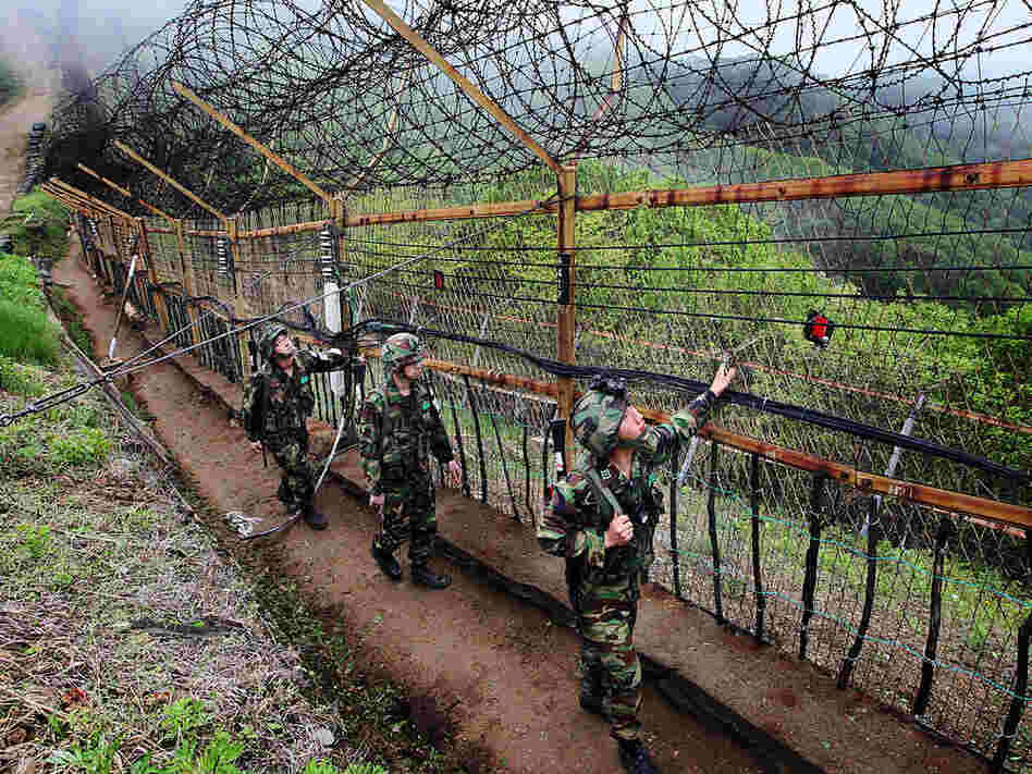 South Korean soldiers patrol along a wire fence at border with North Korea