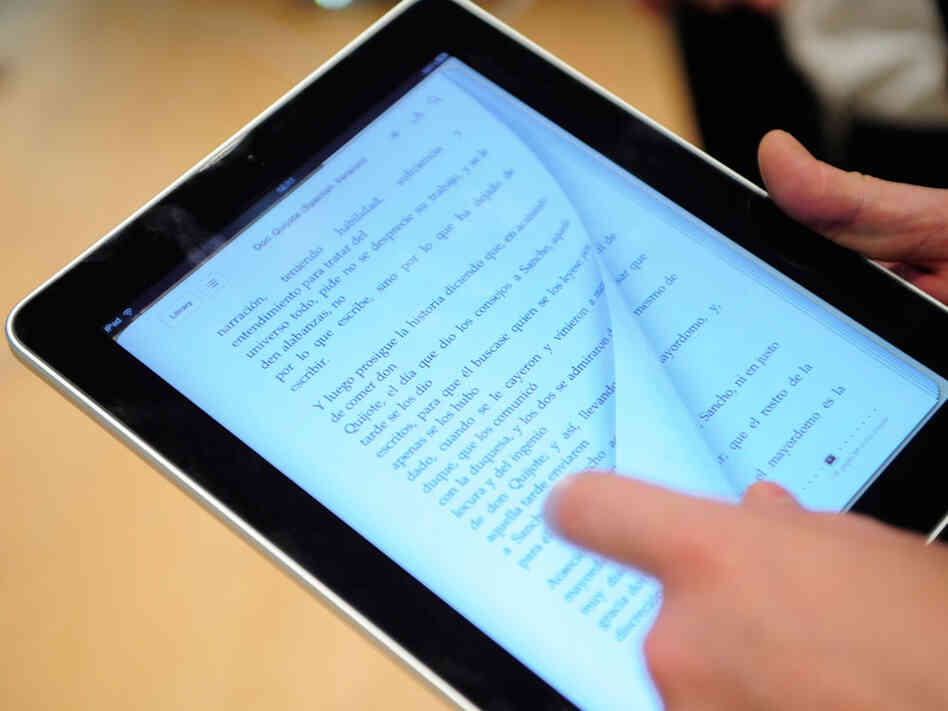 A user flips a book page on an iPad. A user flips a book page on an iPad.