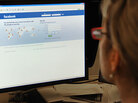 A woman looking at a computer screen showing Facebook A woman looking at a computer screen showing Facebook