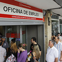 People stand in line outside a government job center in Madrid
