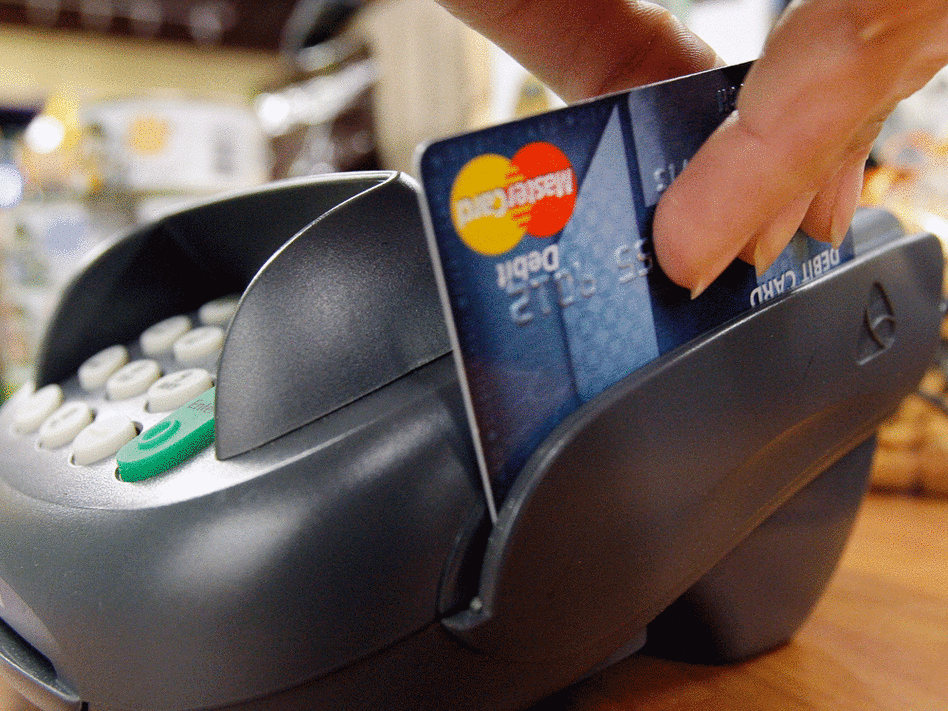 A customer swipes a MasterCard debit card through a machine.