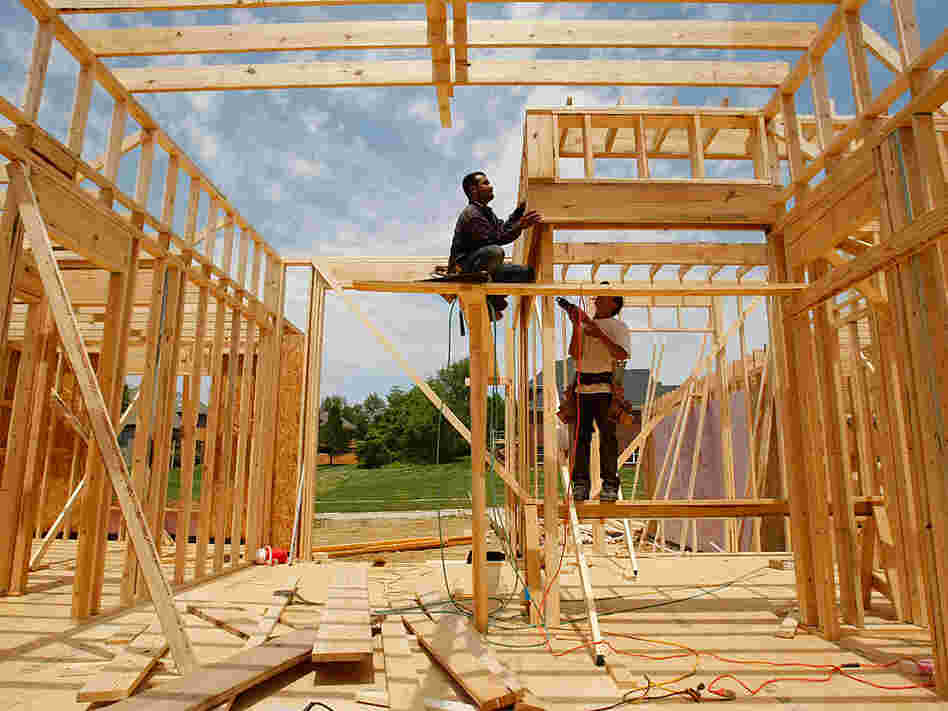 Construction workers frame a house