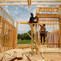 Construction workers frame a house