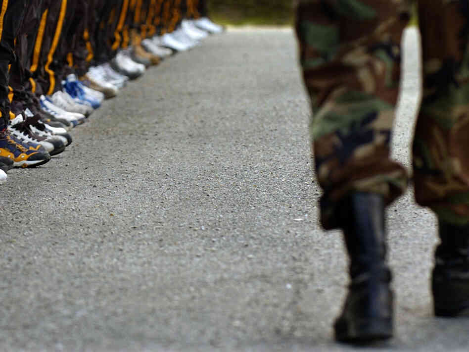 A drill sergeant passes a row of Army National Guard recruits.