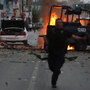 Police officer runs after attack on police trucks in Ciudad Juarez, Mexico, July 15.