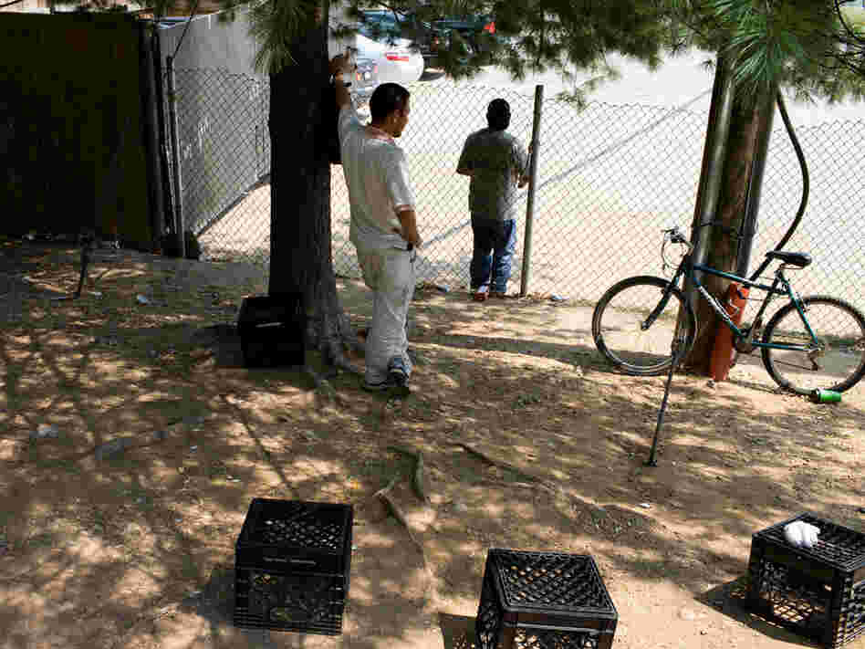 Undocumented day laborers wait along a highway intersection in Manassas, Va., for construction work.