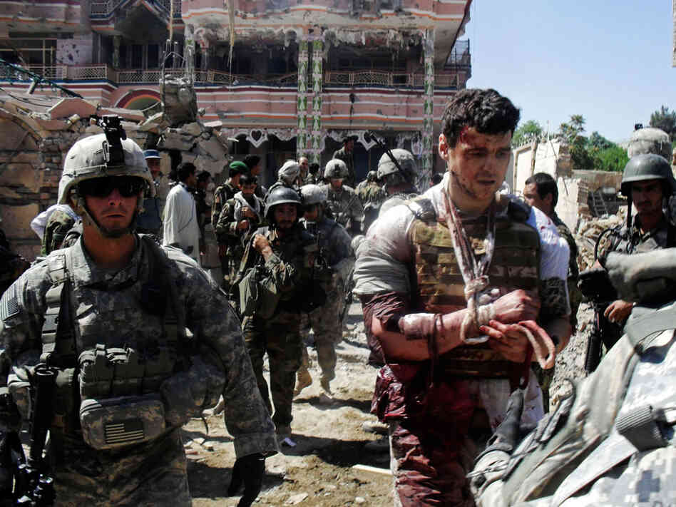 U.S. soldiers escort a wounded foreign contractor