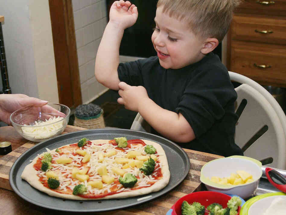 Owen Levine, 3, helps make a broccoli and pineapple pizza for Meatless Monday.