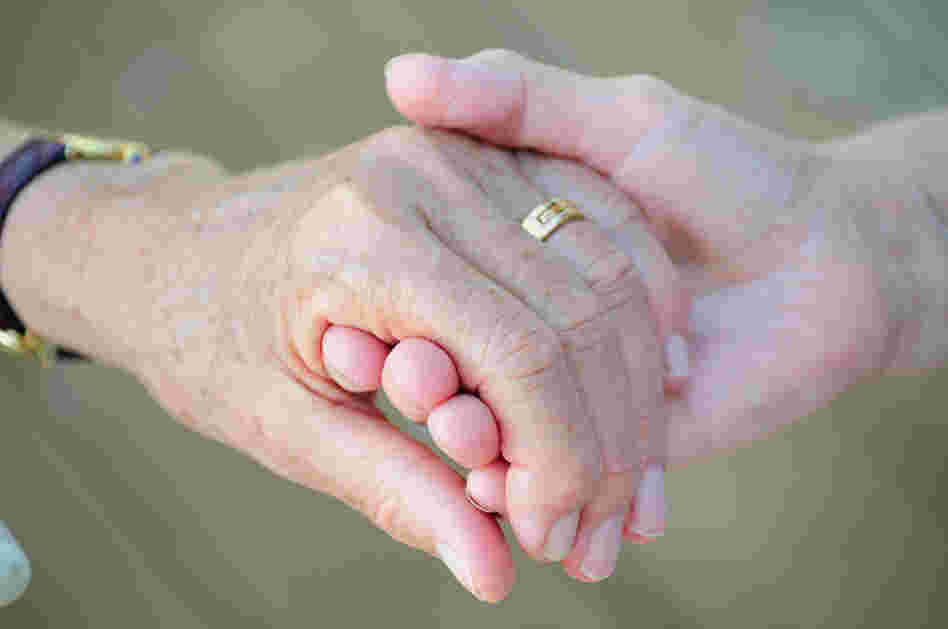 Two older women holding hands