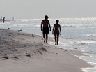 Sunbathers walk along the beach in Pensacola Beach, Fla. on Aug. 1. Sunbathers walk along the beach in Pensacola Beach, Fla. on Aug. 1.