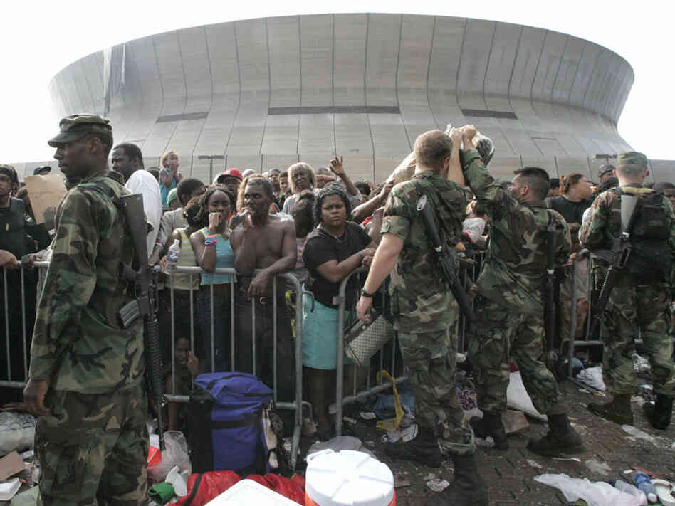 Soldiers stand guard as people wait to leave the Superdome on Sept. 1, 2005.