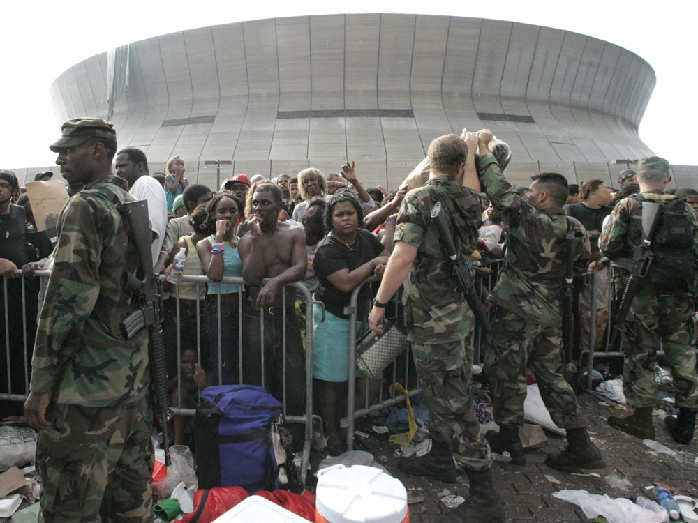 Soldiers stand guard as people wait to leave the Superdome on Sept. 1, 2005.