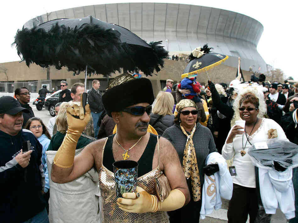 A man in a dress parades past the Superdome to celebrate the Saints' appearance in the Super Bowl.