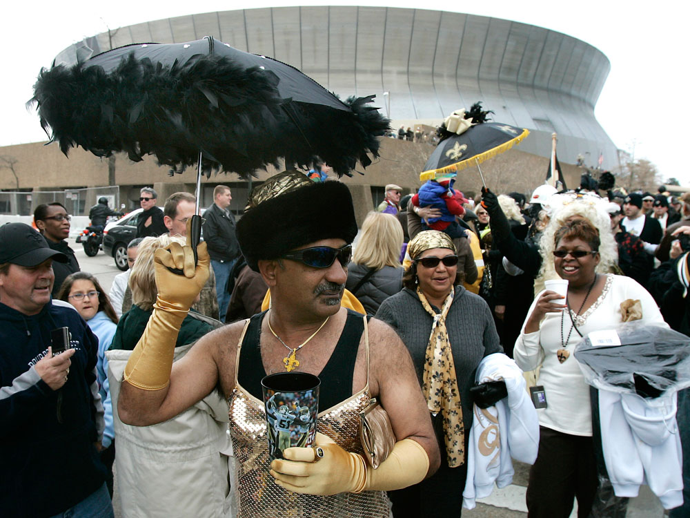 A man in a dress parades past the Superdome to celebrate the Saints' appearance in the Super Bowl.