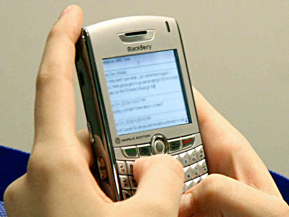 A woman sends text messages on her BlackBerry. A woman sends text messages on her BlackBerry.