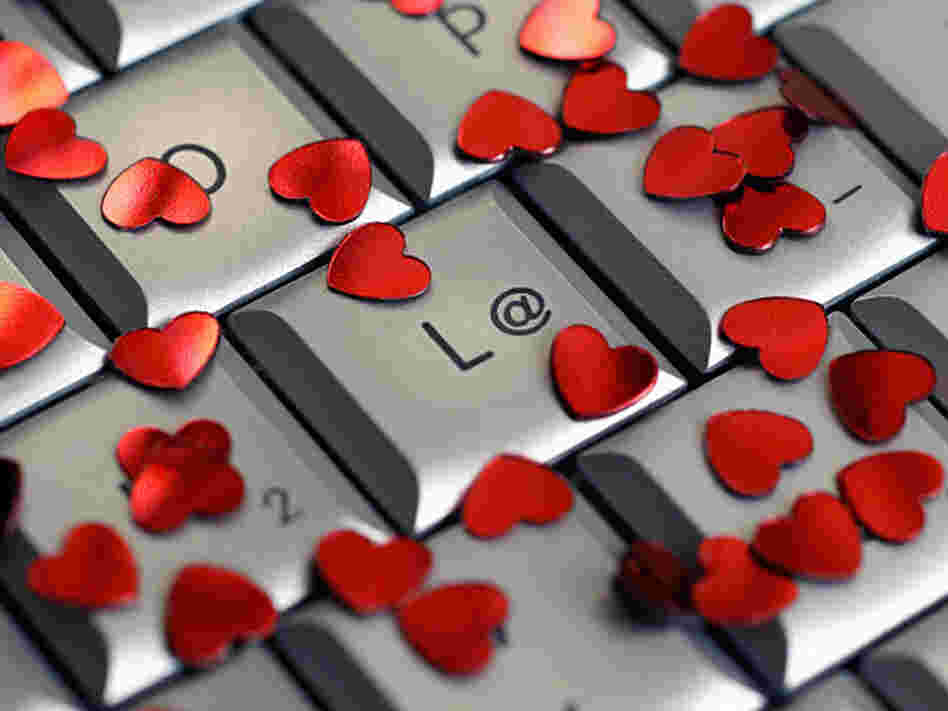 A computer keyboard covered in small red hearts.