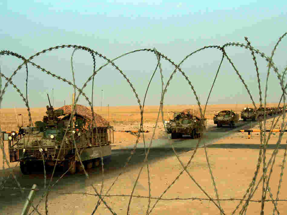 A column of Stryker armored vehicles carrying Army troops crosses the border from Iraq into Kuwait.