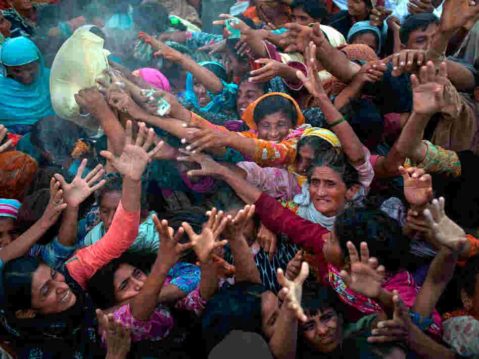Villagers, displaced from their homes by flooding, fight for bags of flour.