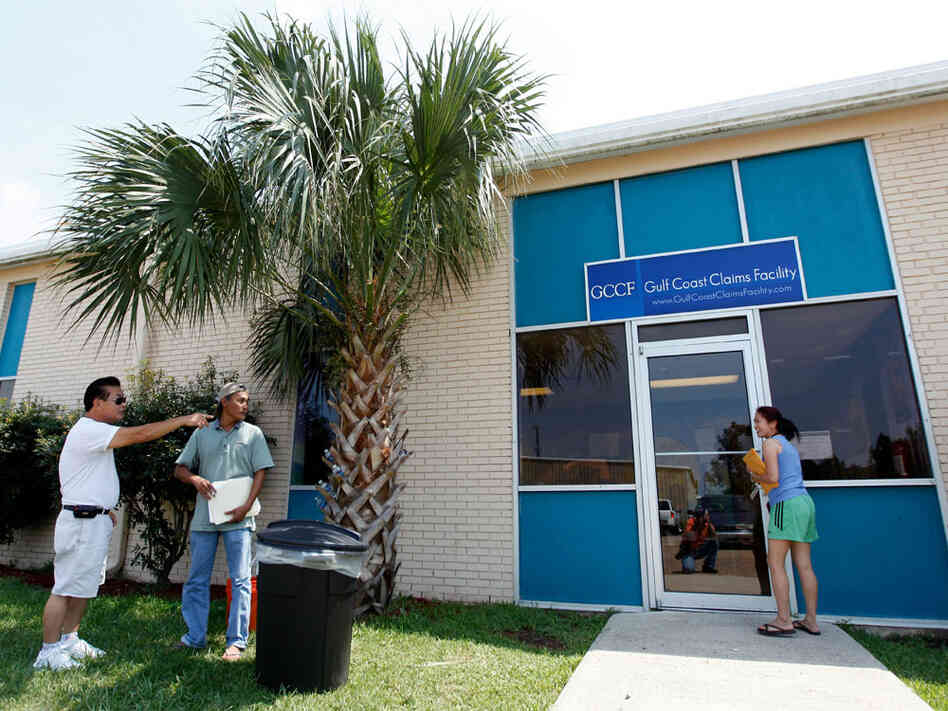 Local residents stand outside the new Gulf Coast Claims Facility in New Orleans
