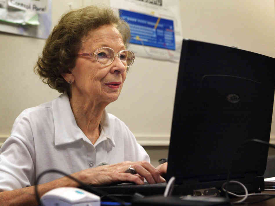 77-year-old Suzette D'Hooghe works on her laptop computer.