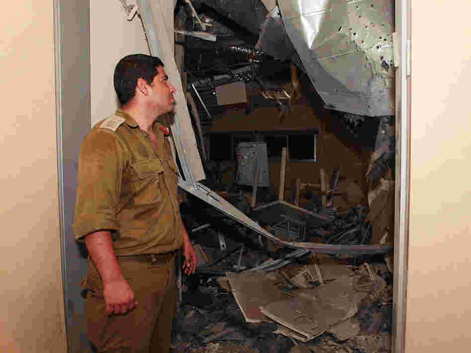 An Israeli military officer in Sderot examines the damage from Palestinian rocket fire