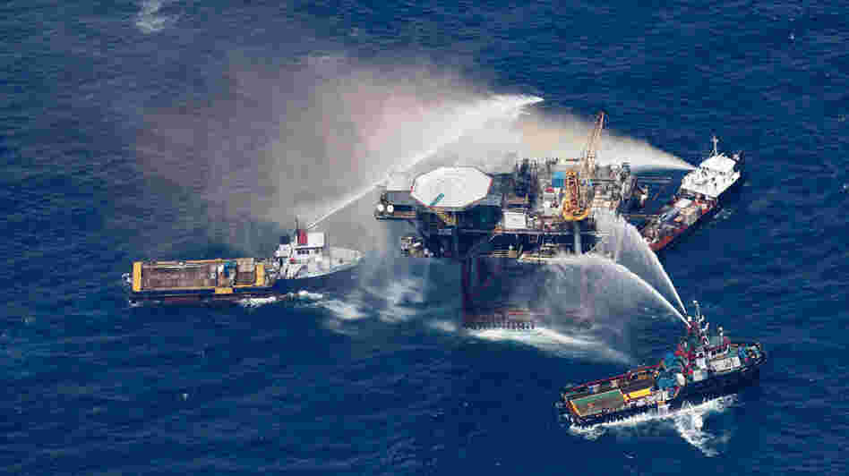 Boats spray water on an oil and gas platform that exploded in the Gulf of Mexico