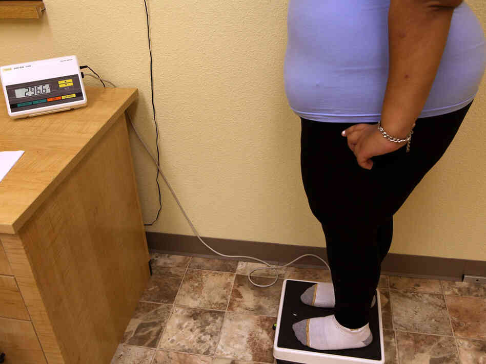 Student stands on scale at weight-loss school.