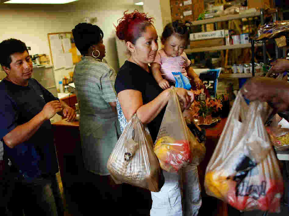 Abran Lopez and Angelina Martinez receive groceries from a food co-op in Fort Lauderdale, Fla.