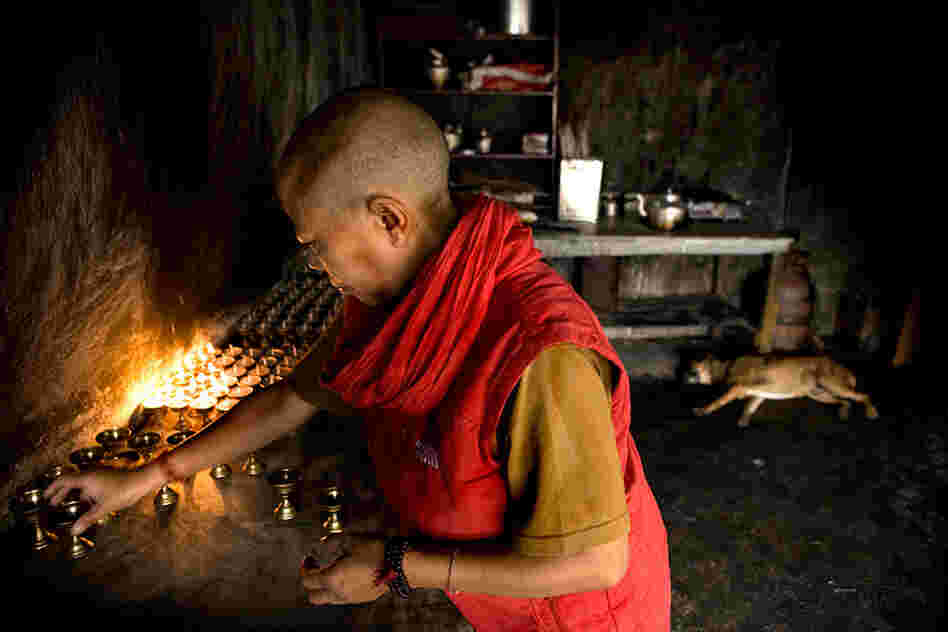 A Tibetan nun lights candles A Tibetan nun lights candles