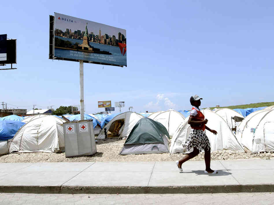 Billboards tower over tent camp near Haiti's international airport
