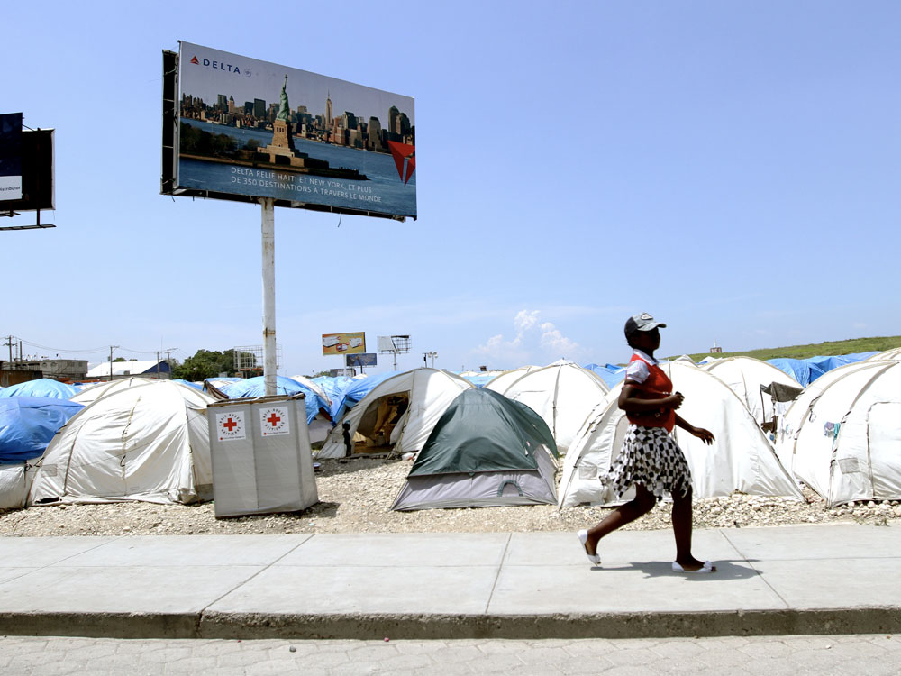 Billboards tower over tent camp near Haiti's international airport