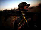 An Afghan soldier slings bullet rounds on his shoulder