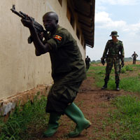 A European soldier oversees training of a Somali soldier at a training camp in Uganda