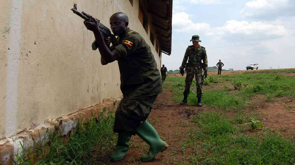 A European soldier oversees training of a Somali soldier at a training camp in Uganda