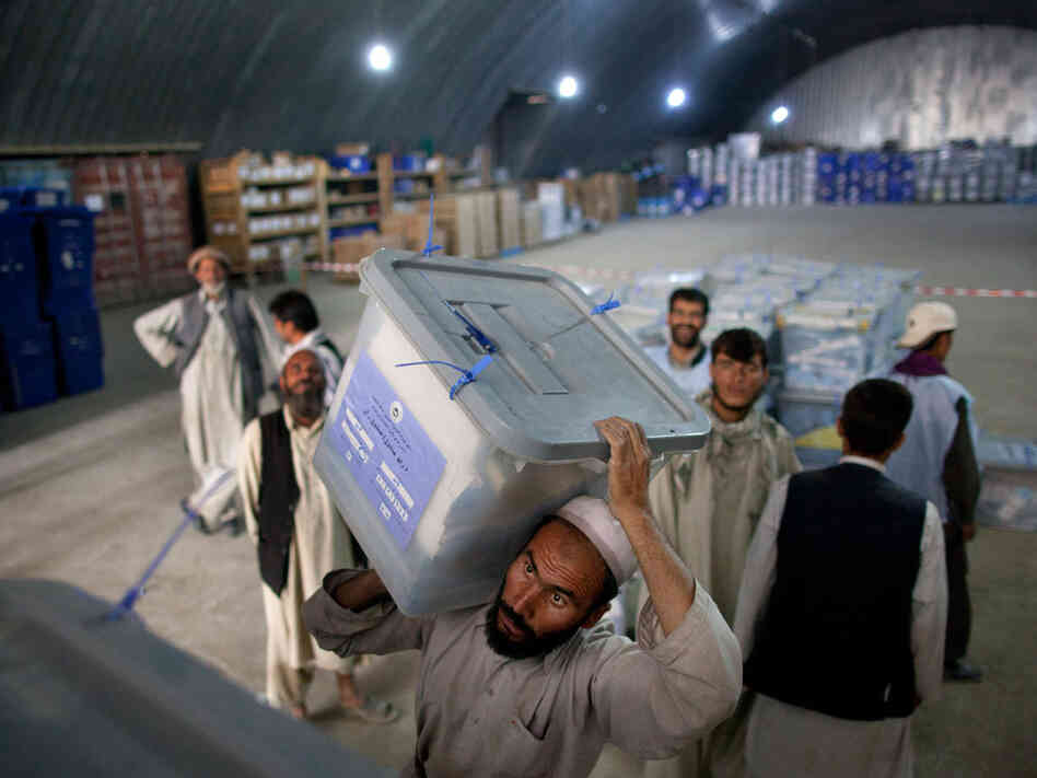 Workers shift ballot boxes at the Independent Election Commission warehouses on Sept. 23. 