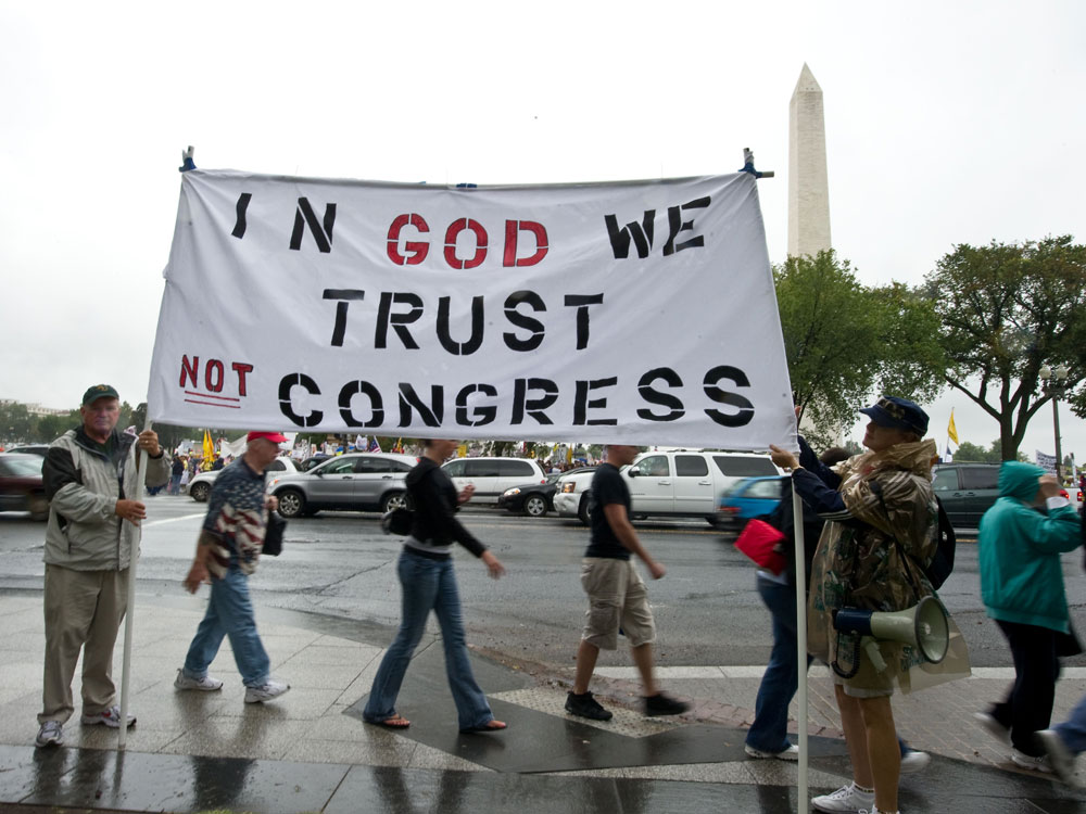 Tea Party supporters hold a sign in front of the Washington Monument during a march on Sept. 12. Tea Party supporters hold a sign in front of the Washington Monument during a march on Sept. 12.