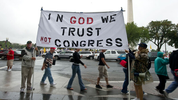 Tea Party supporters hold a sign in front of the Washington Monument during a march on Sept. 12. Tea Party supporters hold a sign in front of the Washington Monument during a march on Sept. 12.
