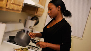 Jada Irwin prepares dinner in the kitchen of her apartment.