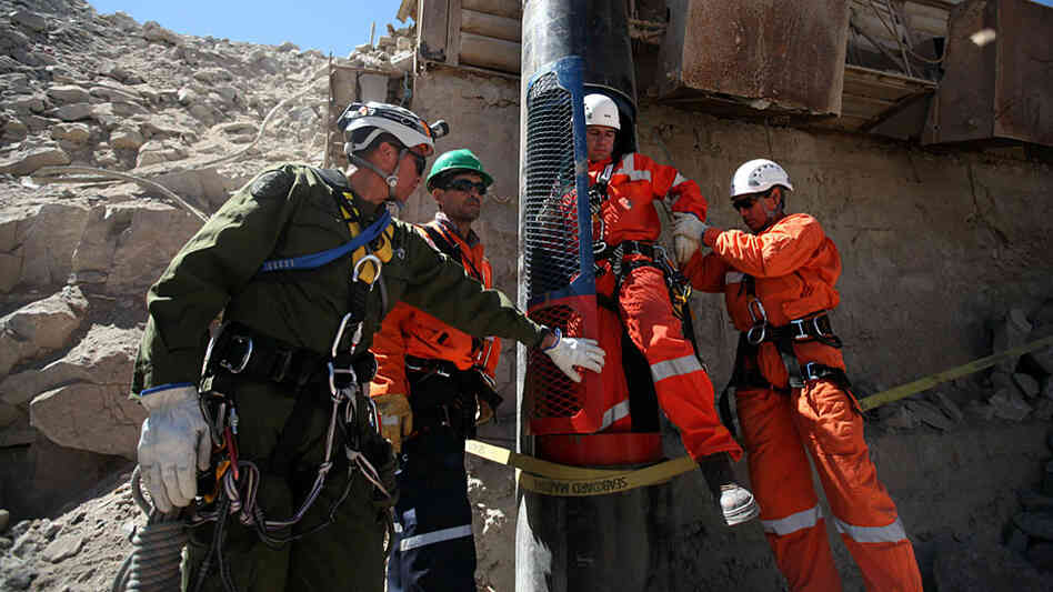 A rescue worker steps out of a capsule.
