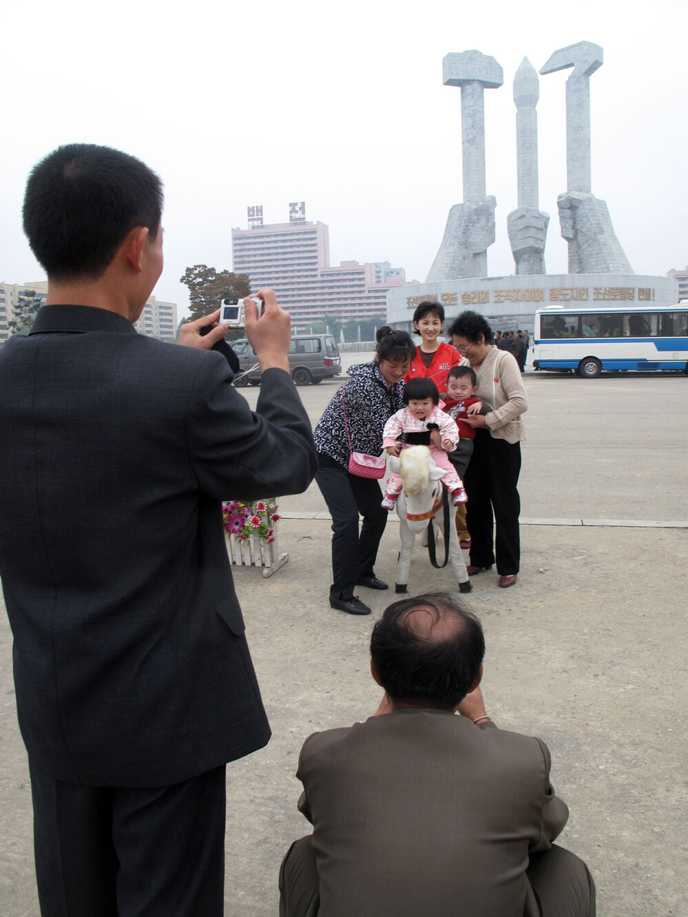 Family poses for photos in front of the monument to the foundation of the Workers Party in Pyongyang