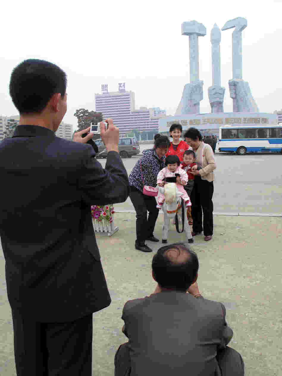 Family poses for photos in front of the monument to the foundation of the Workers Party in Pyongyang